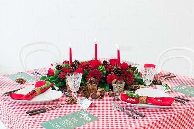 A festive table topped with lots of red wine